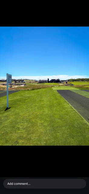 Par-3 championship tee with a US Open branded scoreboard and grandstands in the distance